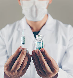 Docteur tenant un vaccin et une seringue